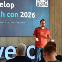 Moderator auf der Bühne der d.velop tech con 2026 vor dem Motto „code smarter, not harder“