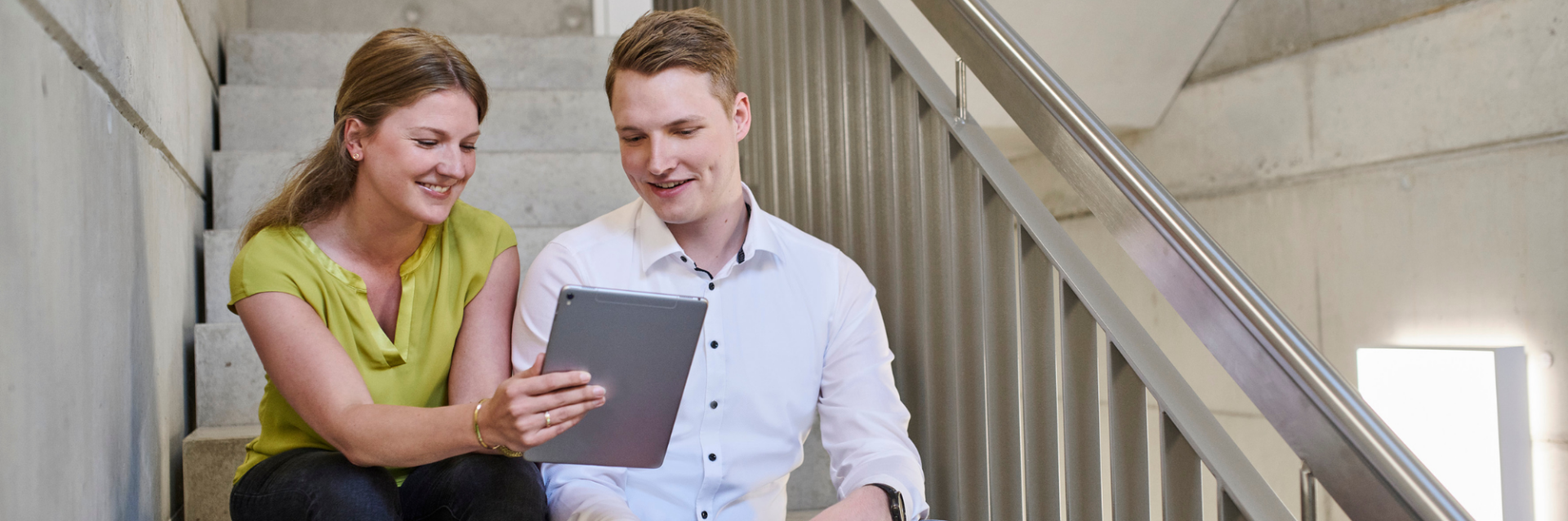 Zwei Mitarbeitende diskutieren eine digitale Signaturlösung auf einem Tablet – Symbol für moderne, rechtssichere digitale Signatur aus Deutschland.