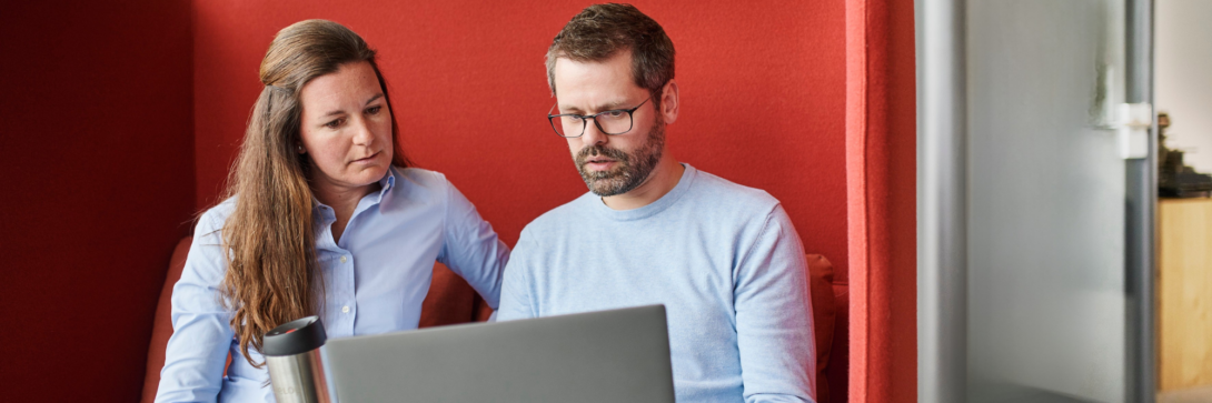 Zwei Mitarbeitende der Verwaltung arbeiten gemeinsam am Laptop und besprechen digitale Lösungen im Rahmen der Verwaltungsdigitalisierung.